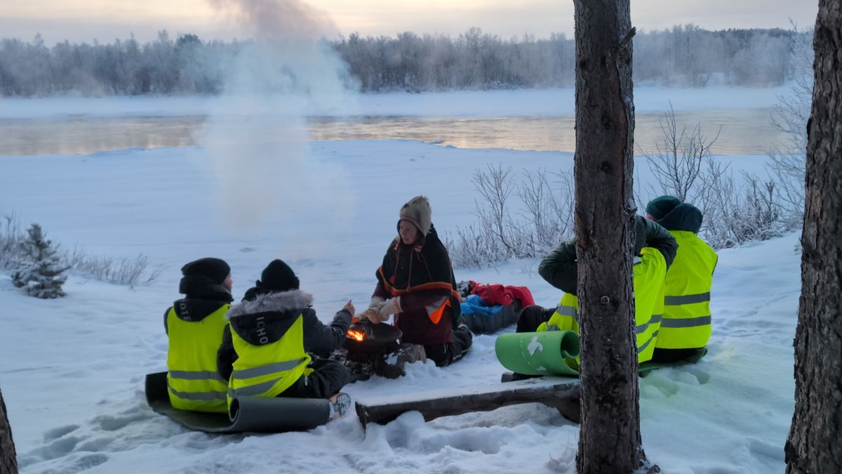 Winter campfire gathering by a frozen lake